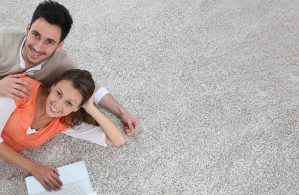 Couple laying on carpet of brand new renovated flat, template